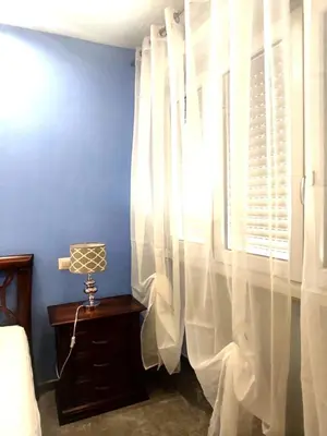 a bedroom with a window with white curtains at Dolce Roma House - Parco Appia Antica , Netflix, Prime e Metro sotto casa in Rome