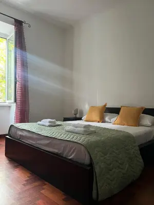 a bedroom with a bed with a green blanket on it at Incontro tra Oriente e Occidente in Rome