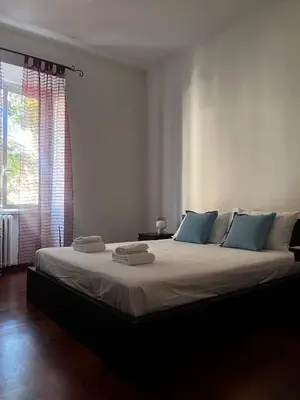 a bedroom with a large bed with blue pillows at Incontro tra Oriente e Occidente in Rome