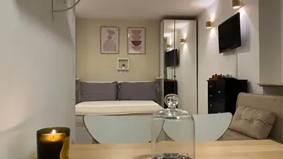 a room with a table and a living room at Elegant Studio at Vatican Museum in Rome