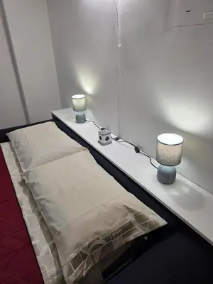 a bed with two lamps on a white table at San Pietro Station 2 in Rome