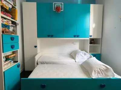 a small bedroom with blue cabinets and a bed at Domus Oleandri - WelcomeToRhome in Rome