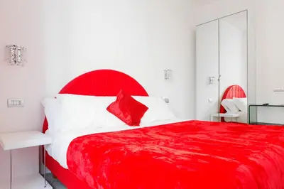 a red bed with white pillows and a red headboard at Vatican Grand Suite in Rome