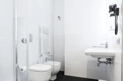 a white bathroom with a toilet and a sink at Vatican Grand Suite in Rome