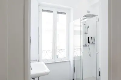 a white bathroom with a shower and a sink at Vatican Grand Suite in Rome
