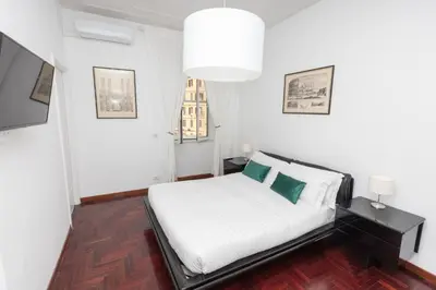 a white bedroom with a bed and a window at Vatican Museum Family Apartment in Rome