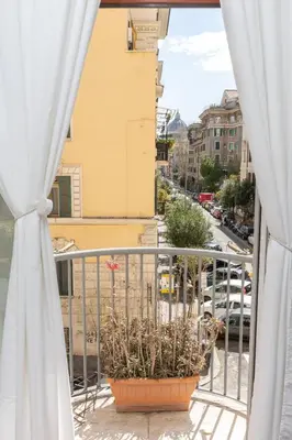 a balcony with a pot of plants on a city street at Vatican Museum Family Apartment in Rome