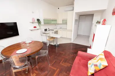 a living room with a table and a kitchen at Vatican Museum Family Apartment in Rome