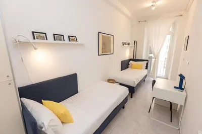 a bedroom with two beds and a table and a desk at Vatican Museum Family Apartment in Rome