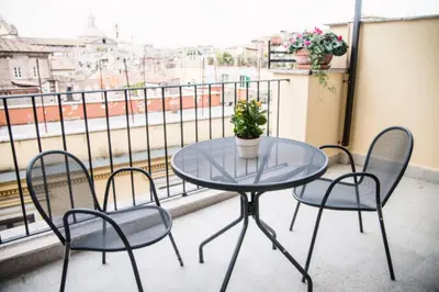 a glass table and chairs on a balcony with a view at Cancelleriadieci in Rome