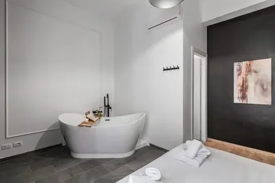 a white bathroom with a tub and a sink at 4 bedrooms, luxury 5 minutes from the Colosseum Jacuzzi in Rome