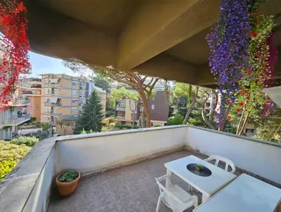 a balcony with a table and chairs and flowers at La Perla in Rome
