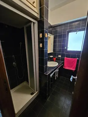 a blue tiled bathroom with a sink and a shower at La Perla in Rome