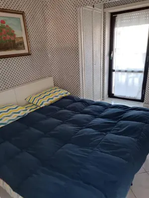 a bedroom with a blue bed with a window at La Perla in Rome