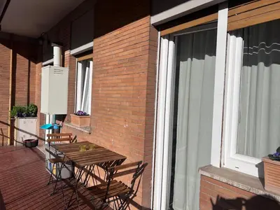 a patio with a wooden table and chairs on a balcony at Appartamento Eataly in Rome