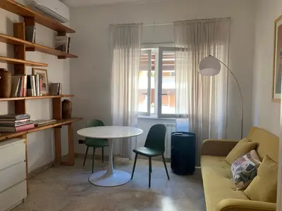 a living room with a table and chairs and a couch at Appartamento Eataly in Rome