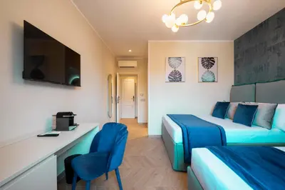 a hotel room with two beds and a desk and a tv at Lussuosa casa zona esquilino in Rome