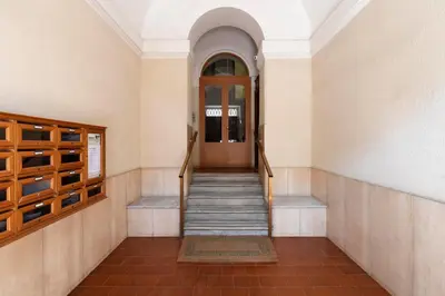 a hallway with a wooden door and stairs at Lussuosa casa zona esquilino in Rome