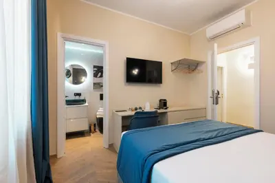 a bedroom with a bed and a desk with a television at Lussuosa casa zona esquilino in Rome