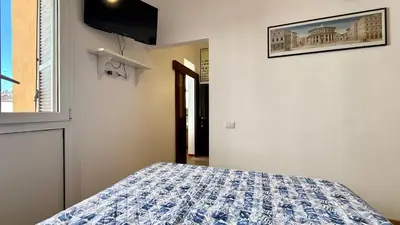 a bedroom with a bed with a blue and white comforter at Il Segreto del Borgo Vaticano in Rome
