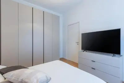 a white bedroom with a tv on a white dresser at Dimora delle Vittorie - Vaticano in Rome