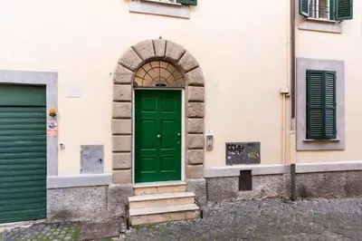 an entrance to a building with a green door at Velantia Fori Apartment in Rome