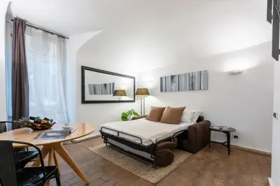 a bedroom with a bed and a table and a desk at Velantia Fori Apartment in Rome