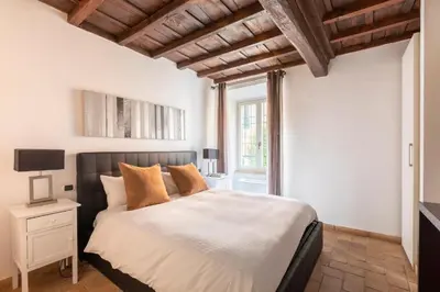 a bedroom with a large bed and a window at Velantia Fori Apartment in Rome