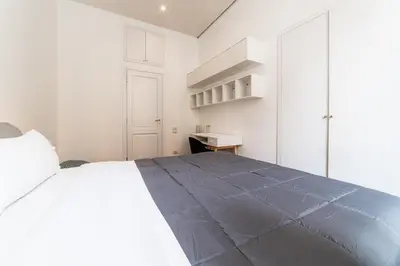 a white bedroom with a large bed and a desk at Casa Lavinia - Basilica Santa Maria Maggiore in Rome