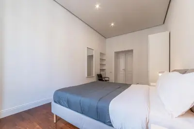 a bedroom with a large white bed and a chair at Casa Lavinia - Basilica Santa Maria Maggiore in Rome
