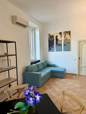 a living room with a blue couch and a table at Domus Mantellate, Trastevere in Rome