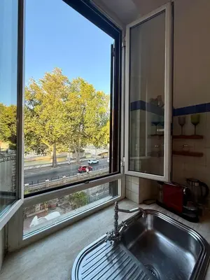 a kitchen with a sink and a large window at Domus Mantellate, Trastevere in Rome