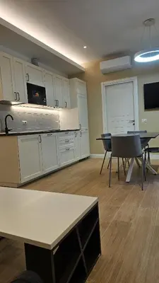 a kitchen with white cabinets and a table and chairs at La Belle Étoile in Rome