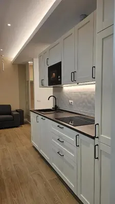 a kitchen with white cabinets and a sink and a couch at La Belle Étoile in Rome