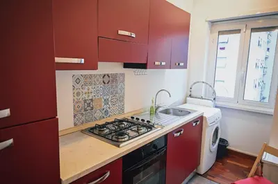 a kitchen with red cabinets and a stove and a sink at Room in Rome in Rome
