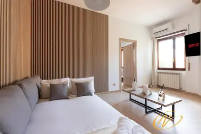 a living room with a large white bed and a table at Nuccia Luxury Apartment and Suites - Terrace, bright glass lounge, 200mt to Metro-5min to Vatican, A-C in Rome