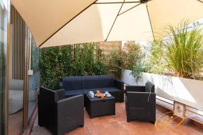 a patio with two chairs and an umbrella at Nuccia Luxury Apartment and Suites - Terrace, bright glass lounge, 200mt to Metro-5min to Vatican, A-C in Rome