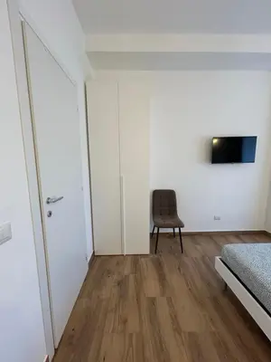 a bedroom with white walls and a bed and a chair at Interno 2 alle Mura in Rome