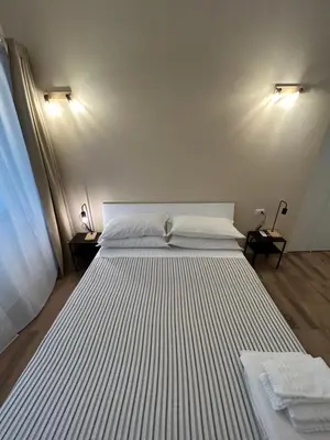 a large white bed in a room with two lamps at Interno 2 alle Mura in Rome