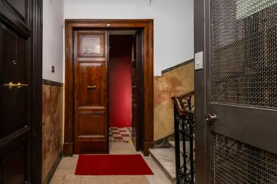 a hallway with a wooden door and a red rug at Piazza Vittorio Urban Stay in Rome