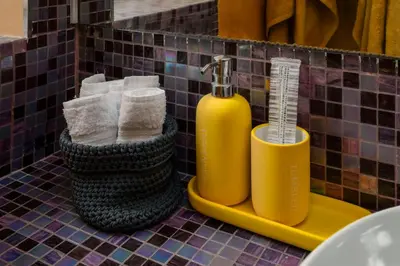 a bathroom with a yellow soap dispenser and towels at Piazza Vittorio Urban Stay in Rome