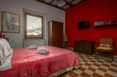 a red bedroom with a bed with two towels on it at Piazza Vittorio Urban Stay in Rome