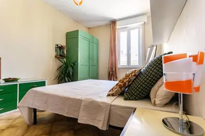 a bedroom with a bed and a green cabinet at Ampia stanza luminosa a San Giovanni, piano alto con finestra o balcone in Rome