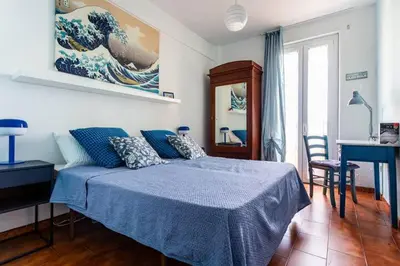 a bedroom with a blue bed and a desk and a table at Ampia stanza luminosa a San Giovanni, piano alto con finestra o balcone in Rome