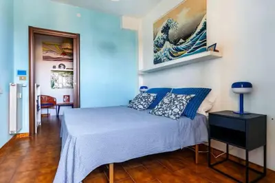 a bedroom with a bed and a painting on the wall at Ampia stanza luminosa a San Giovanni, piano alto con finestra o balcone in Rome