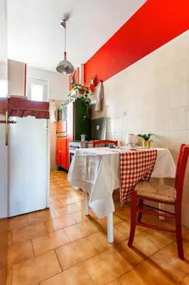 a kitchen with a table and a refrigerator at Ampia stanza luminosa a San Giovanni, piano alto con finestra o balcone in Rome