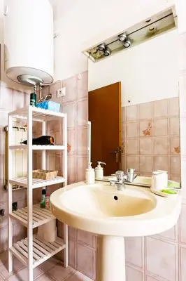 a bathroom with a sink and a mirror at Ampia stanza luminosa a San Giovanni, piano alto con finestra o balcone in Rome