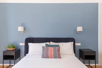a bedroom with a bed with a blue wall at iFlat The Sweet Life in Rome in Rome