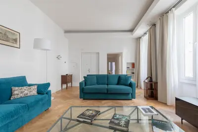 a living room with two blue couches and a glass table at iFlat The Sweet Life in Rome in Rome