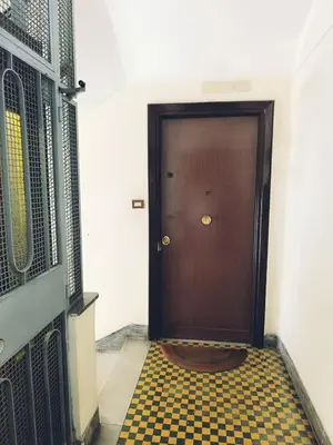a wooden door with a checkered floor in a hallway at Elegant apartment 5 minutes from the subway in Rome